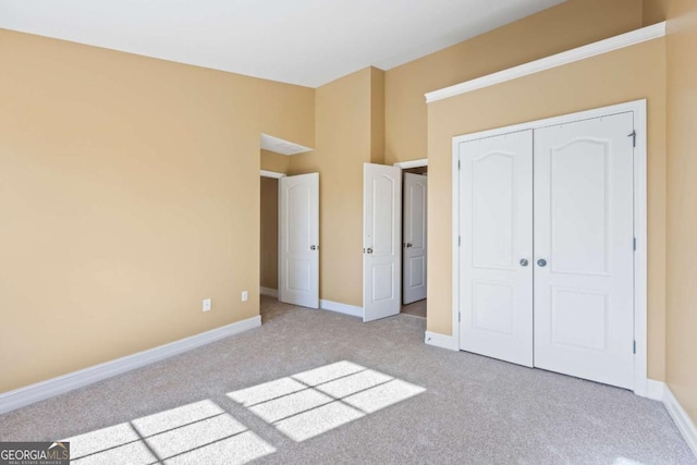 unfurnished bedroom with a closet and light colored carpet