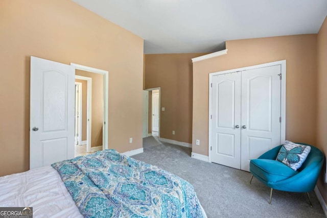 bedroom with carpet flooring, a closet, and vaulted ceiling