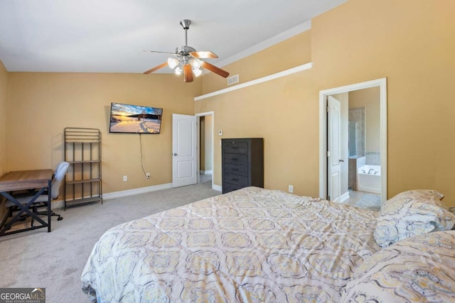 carpeted bedroom featuring vaulted ceiling, ensuite bath, and ceiling fan