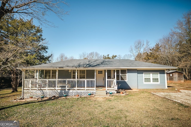 view of front facade featuring covered porch, a storage unit, and a front yard