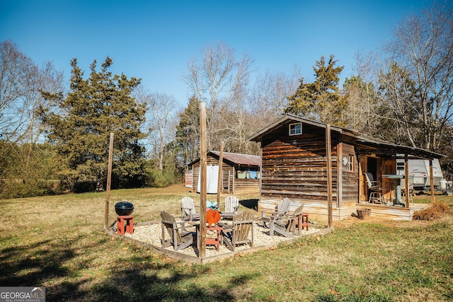 exterior space featuring a yard, a fire pit, and a shed