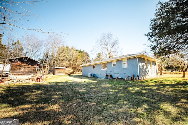 exterior space featuring a yard, an outdoor structure, and central AC unit