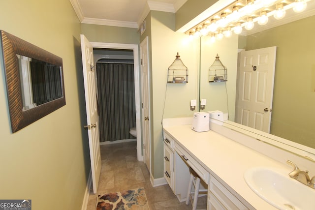 bathroom with toilet, vanity, and ornamental molding