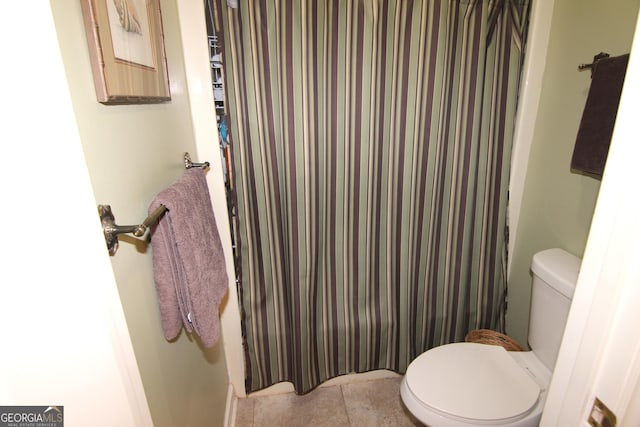 bathroom featuring tile patterned flooring, a shower with curtain, and toilet