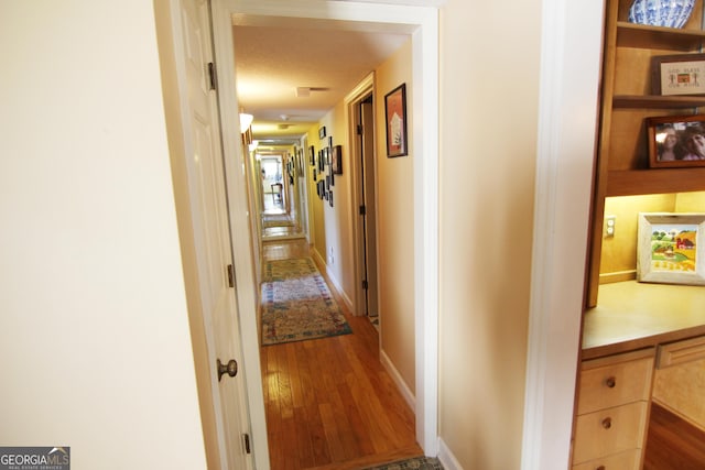 hallway featuring a textured ceiling and hardwood / wood-style flooring