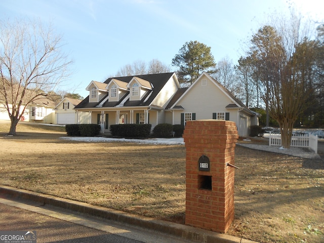 cape cod-style house featuring a front yard