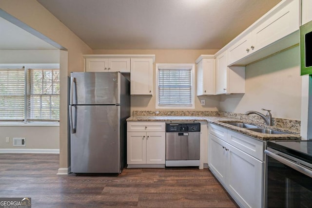 kitchen featuring light stone countertops, stainless steel appliances, and white cabinetry