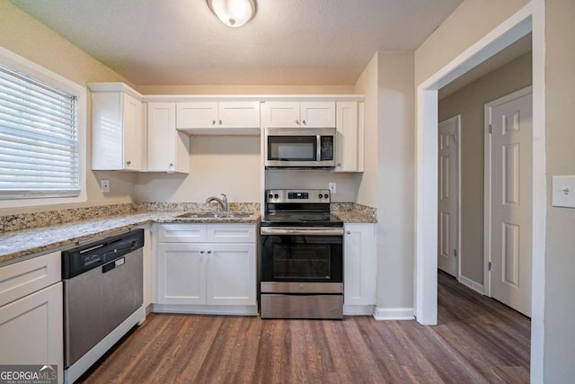 kitchen with sink, light stone countertops, white cabinetry, and stainless steel appliances