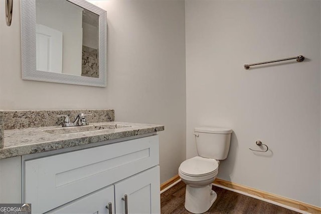 bathroom featuring toilet, hardwood / wood-style flooring, and vanity