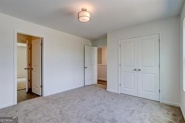 unfurnished bedroom with a closet and light carpet