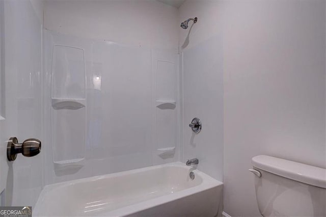 bathroom with washtub / shower combination and toilet