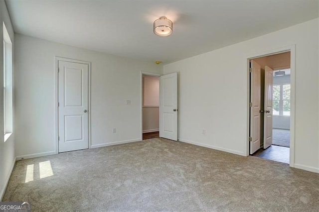 unfurnished bedroom with a closet and light colored carpet