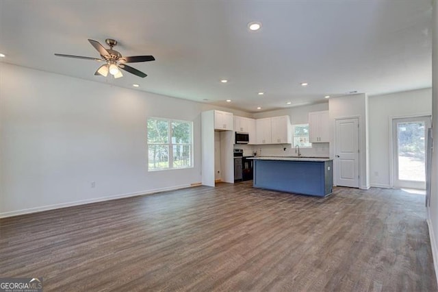 kitchen with sink, white cabinetry, a center island, ceiling fan, and hardwood / wood-style flooring