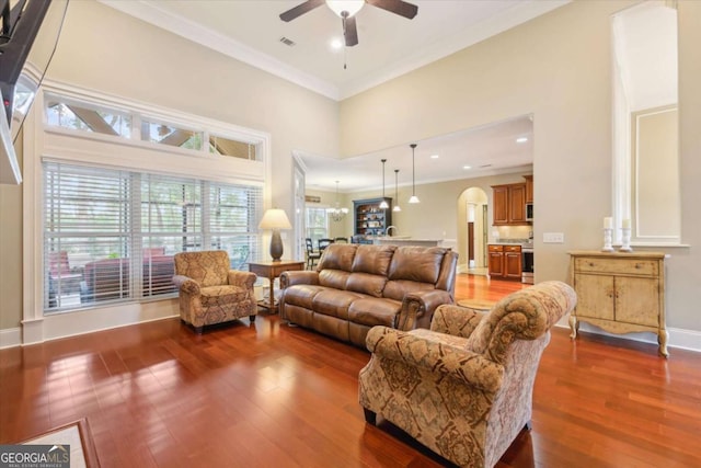 living room featuring dark hardwood / wood-style flooring, ceiling fan, and ornamental molding