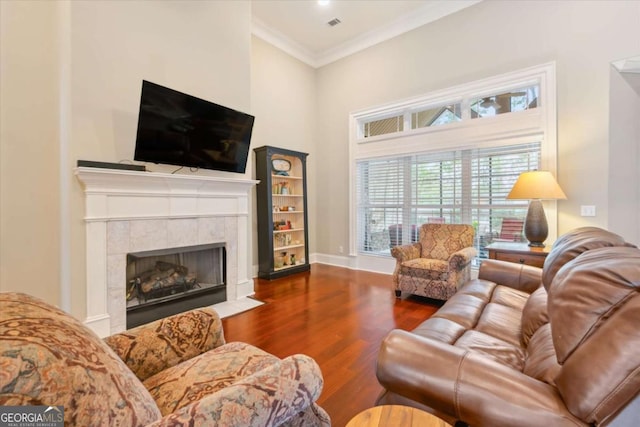 living room with dark hardwood / wood-style floors, crown molding, and a tile fireplace