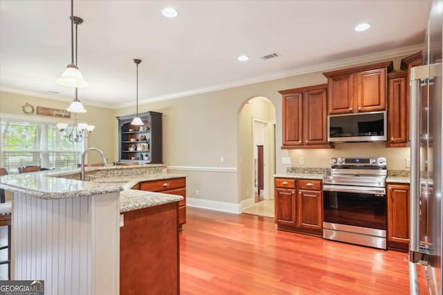 kitchen with sink, hanging light fixtures, crown molding, an island with sink, and appliances with stainless steel finishes