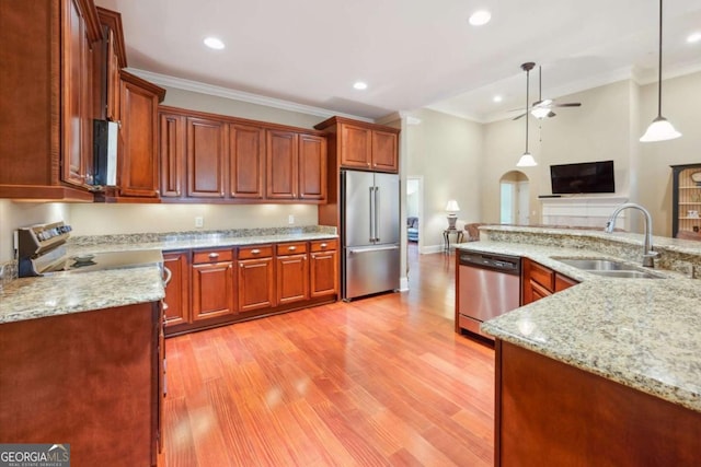 kitchen with sink, ceiling fan, appliances with stainless steel finishes, decorative light fixtures, and light stone counters