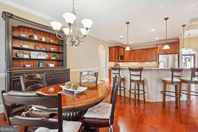 dining space with crown molding, a chandelier, and dark hardwood / wood-style floors