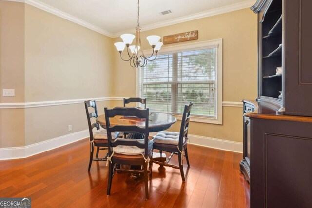 dining area featuring a chandelier, dark hardwood / wood-style flooring, crown molding, and a healthy amount of sunlight