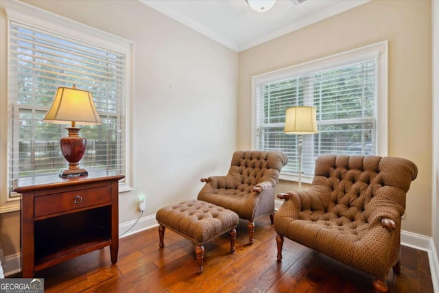 living area with wood-type flooring and ornamental molding