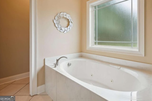 bathroom with a tub to relax in and tile patterned flooring