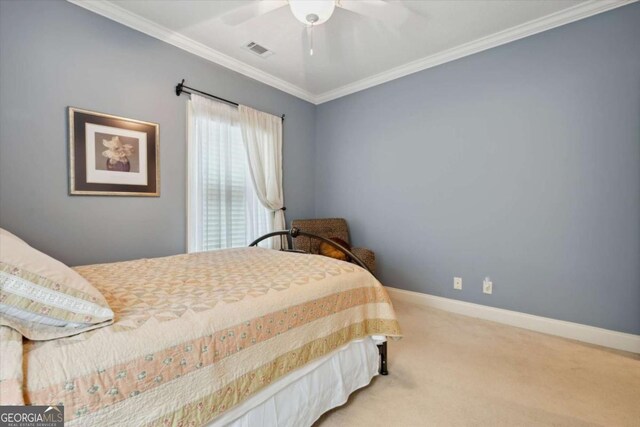 bedroom featuring ceiling fan, crown molding, and carpet floors