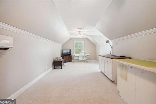 additional living space with ceiling fan, light colored carpet, and vaulted ceiling