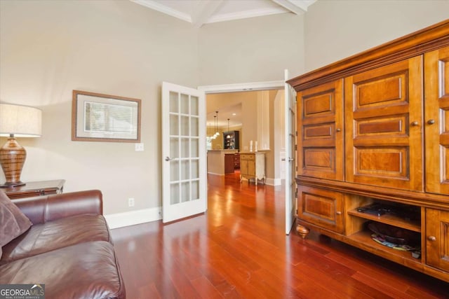 living room with dark hardwood / wood-style floors, beam ceiling, and crown molding