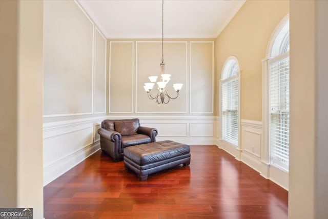 sitting room with an inviting chandelier and dark wood-type flooring