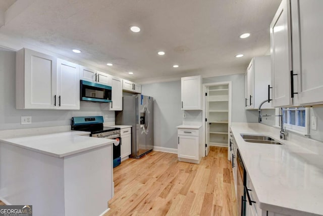 kitchen featuring white cabinets, light hardwood / wood-style floors, sink, and appliances with stainless steel finishes