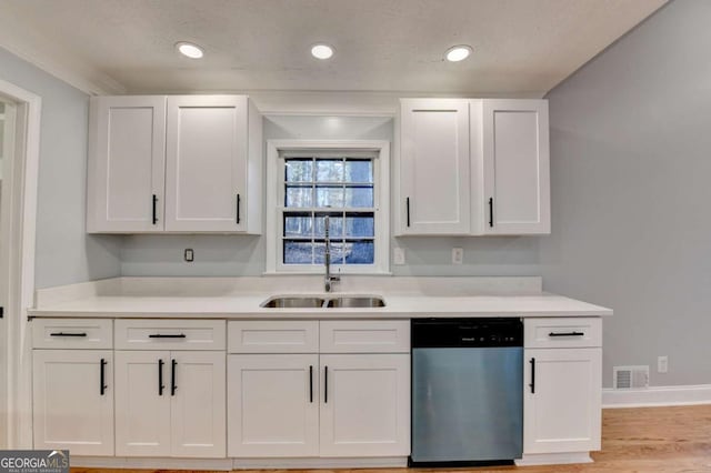 kitchen featuring a textured ceiling, sink, light hardwood / wood-style flooring, dishwasher, and white cabinetry