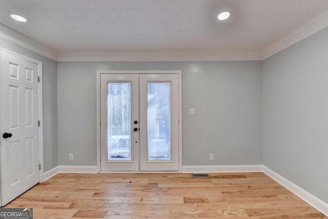 doorway to outside with ornamental molding, light hardwood / wood-style flooring, and french doors