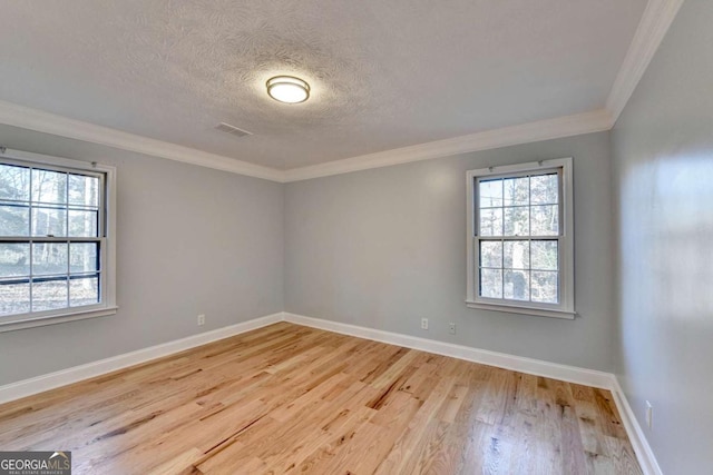 unfurnished room with a textured ceiling, light hardwood / wood-style flooring, and crown molding