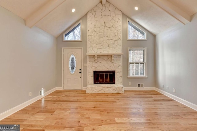 unfurnished living room featuring beamed ceiling, light hardwood / wood-style floors, a fireplace, and high vaulted ceiling