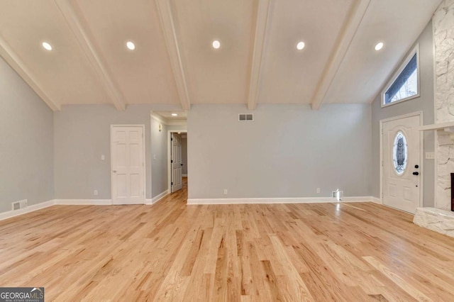 entryway with beamed ceiling, high vaulted ceiling, light hardwood / wood-style floors, and a stone fireplace