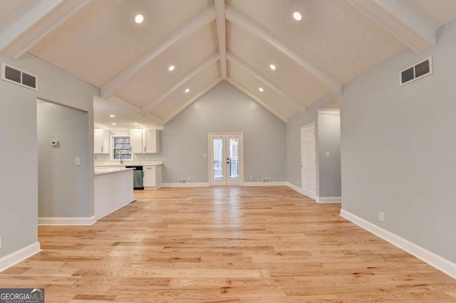 unfurnished living room with beamed ceiling, french doors, high vaulted ceiling, and light hardwood / wood-style flooring