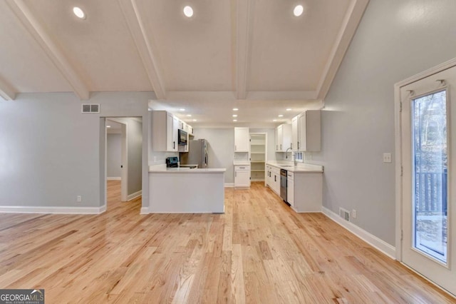 kitchen featuring stainless steel appliances, sink, beamed ceiling, light hardwood / wood-style floors, and white cabinetry