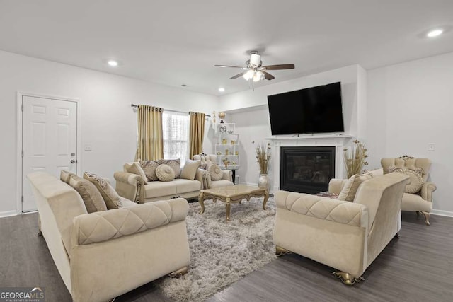 living room featuring ceiling fan and dark wood-type flooring