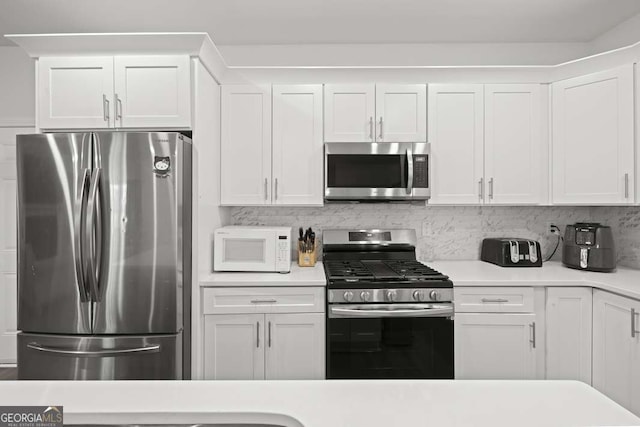 kitchen with tasteful backsplash, white cabinetry, and appliances with stainless steel finishes