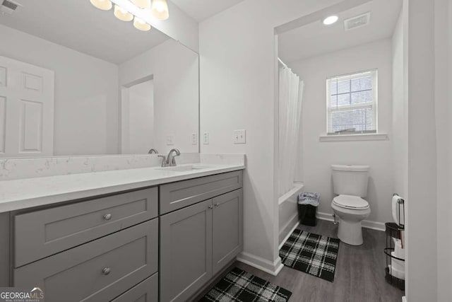 full bathroom with vanity, hardwood / wood-style flooring, toilet, and shower / bathtub combination with curtain