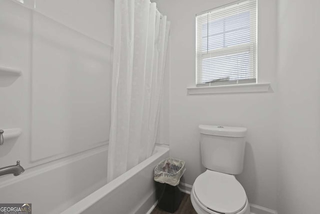 bathroom featuring shower / bath combination with curtain and toilet