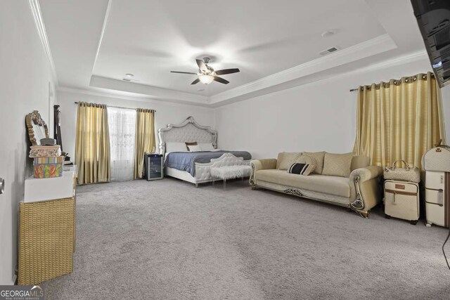 bedroom with a tray ceiling, ceiling fan, and carpet floors