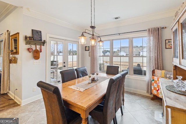 dining area with light tile patterned floors, french doors, crown molding, and a chandelier