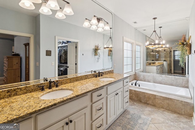 bathroom with vanity, tile patterned floors, and tiled tub