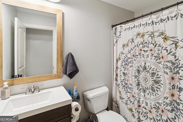 bathroom featuring curtained shower, toilet, and vanity