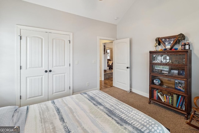 bedroom featuring lofted ceiling, a closet, and carpet floors