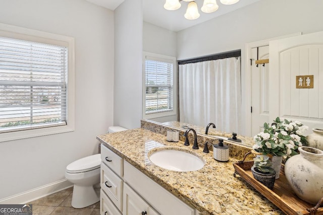 bathroom featuring toilet, a healthy amount of sunlight, vanity, and tile patterned floors