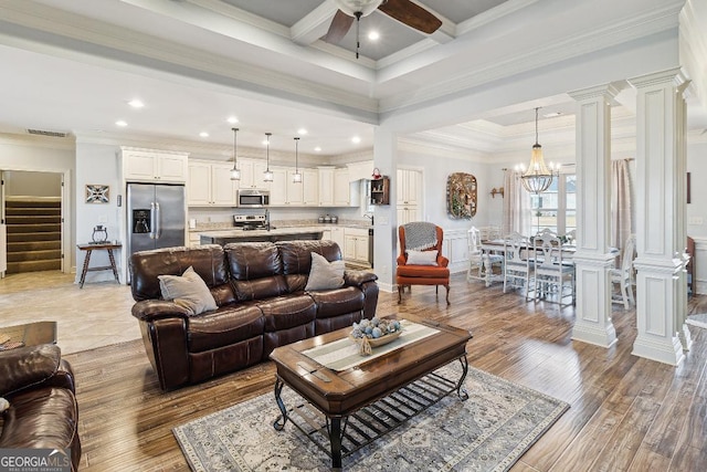 living room featuring beam ceiling, sink, light wood-type flooring, ornamental molding, and ceiling fan with notable chandelier