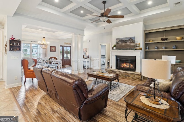 living room with a fireplace, ceiling fan with notable chandelier, beam ceiling, and coffered ceiling