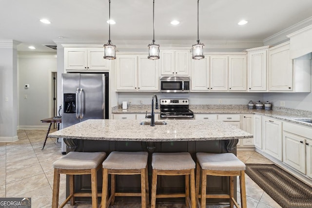 kitchen with light stone countertops, a kitchen bar, stainless steel appliances, sink, and a kitchen island with sink